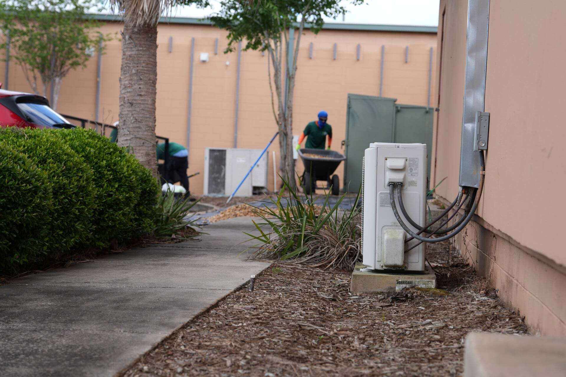 Two crew members installing a rock bed beside a commercial building